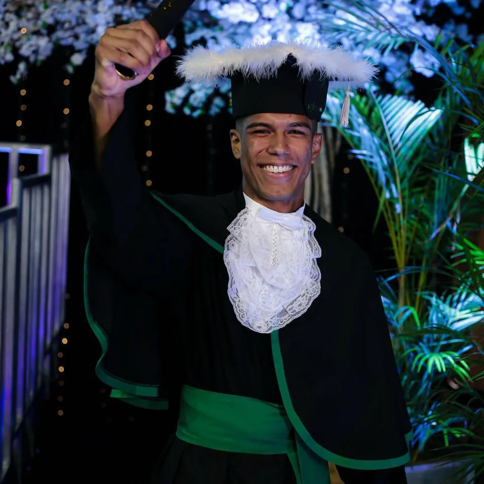 Flávio Barbosa sorrindo em traje de formatura.